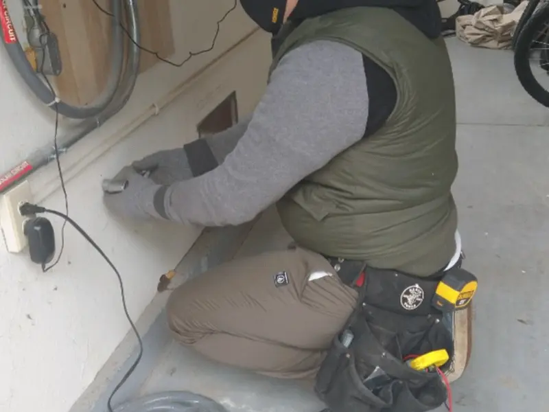 Electrician performing outlet wiring in a Tiffin garage